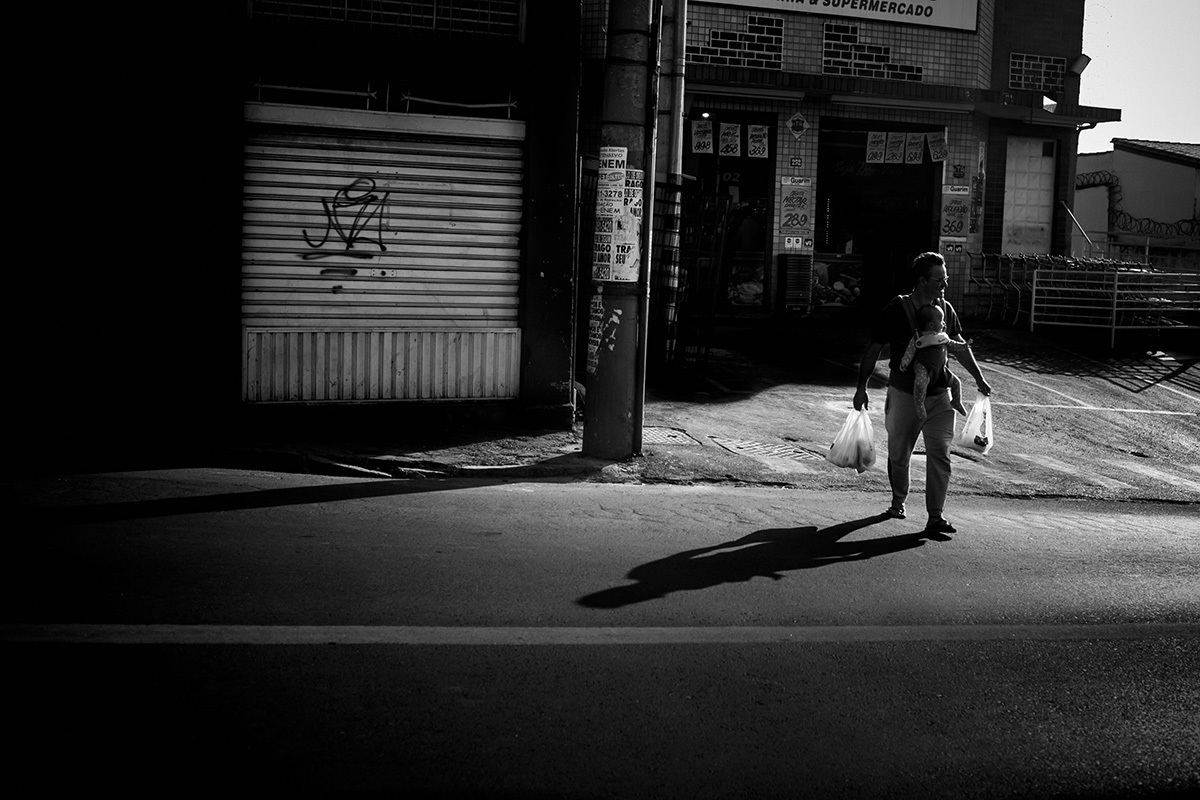 pai saindo da padaria com sua bebê de um ano, em foto de Adriana Costa
