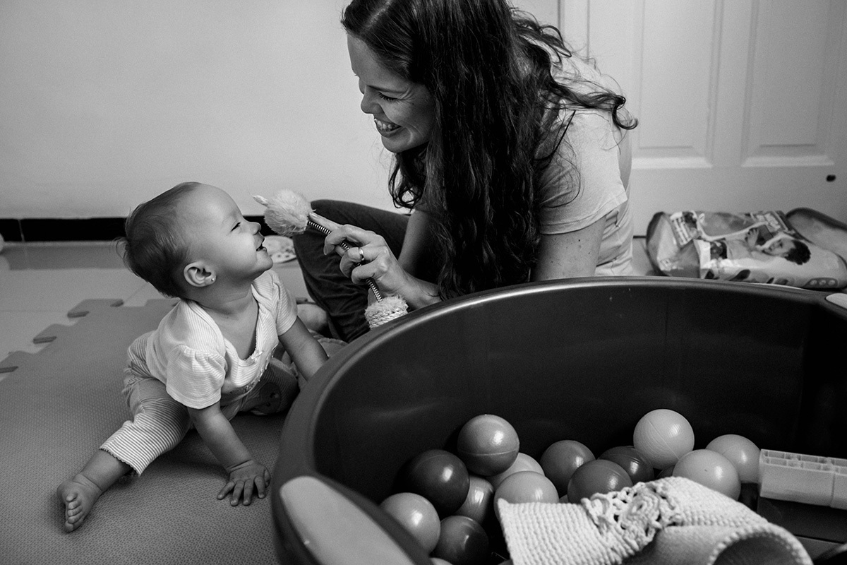 mãe e sua filha de um ano brincando juntas, por Adriana Costa