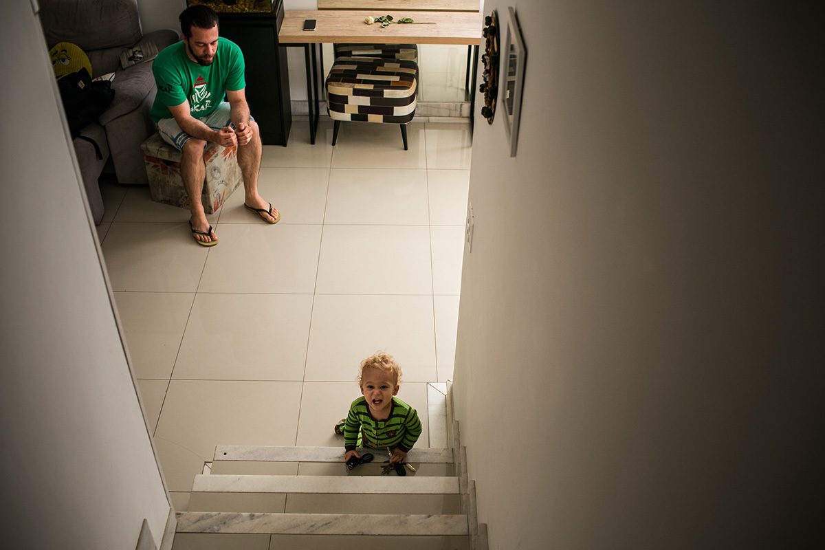 menino de um ano chama por sua mãe no primeiro degrau do andar debaixo de sua casa