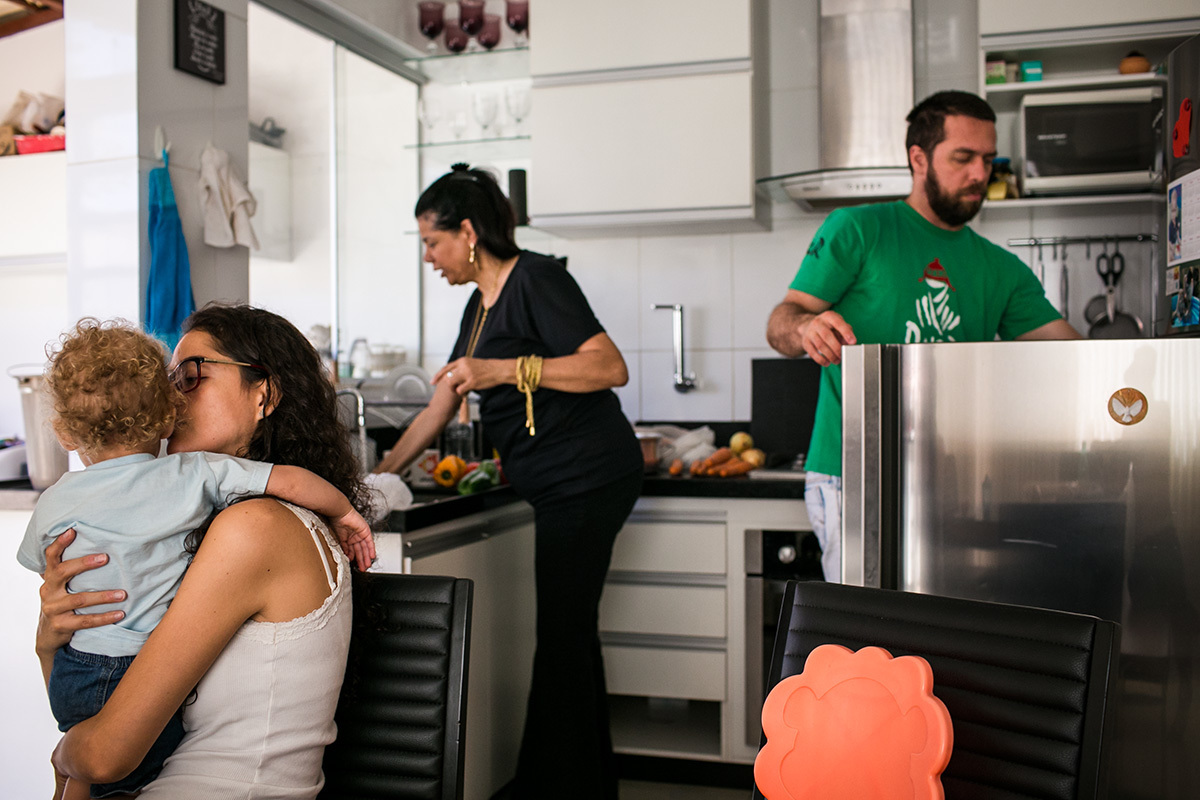 família na cozinha cada um realizando uma atividade