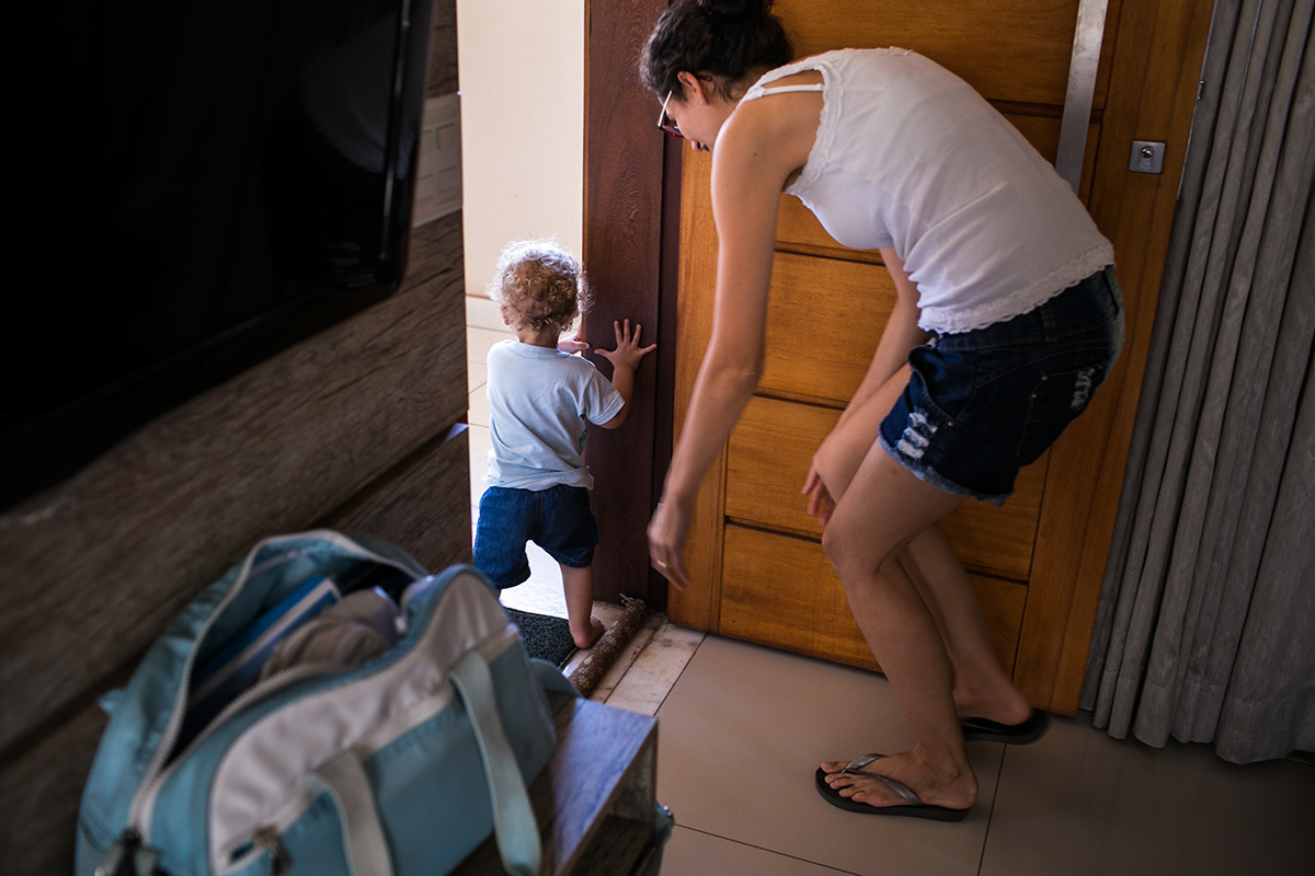 mãe e filho saindo pela porta da casa para passear