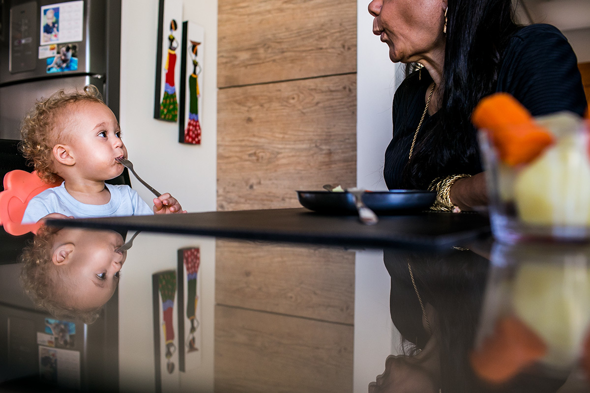 avó manda beijo para o neto que está almoçando