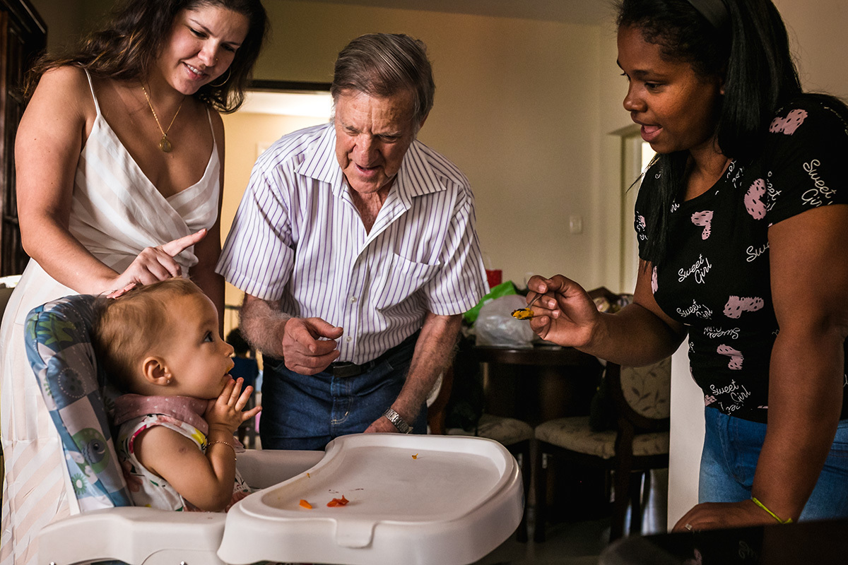 avô e tia brincam com a aniversariante enquanto ela almoça, por adrianacostafotos