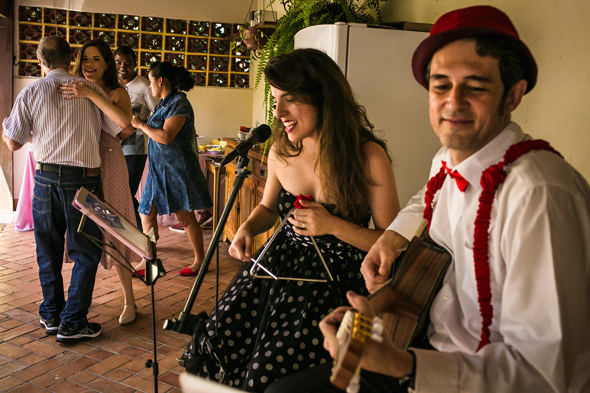 mãe a avô da aniversariante dançam ao som dos músicos durante sua festa de 1 ano