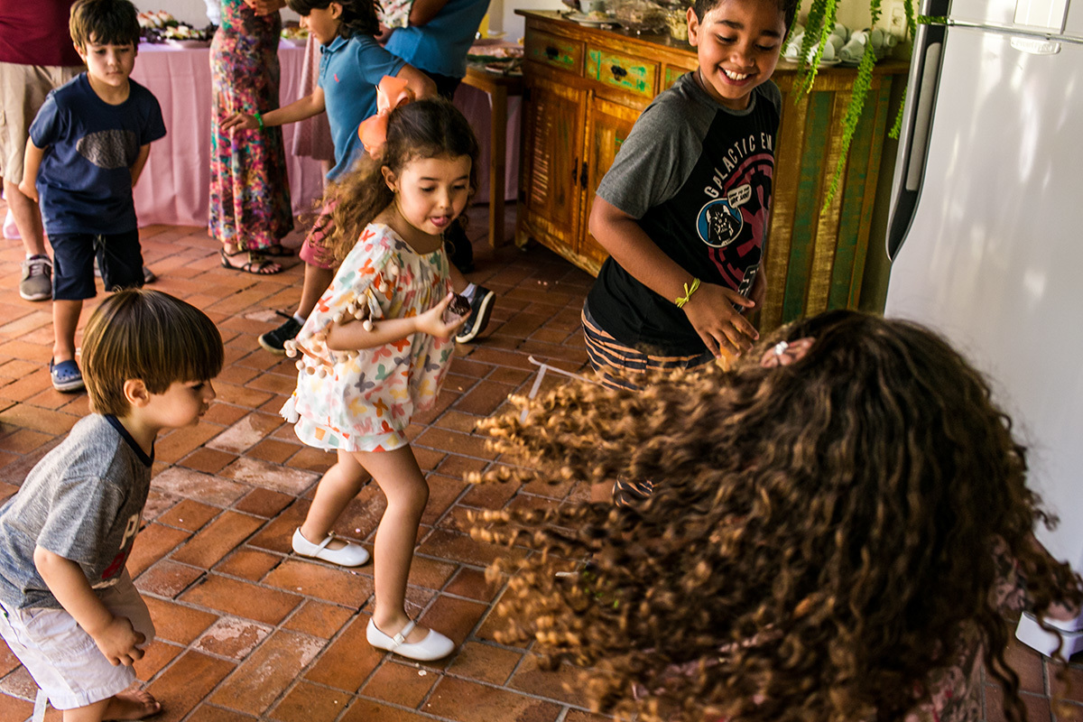 crianças correndo para pegar o seu lugar durante uma brincadeira infantil realizada em uma festa de aniversario de 1 ano, por Adriana Costa
