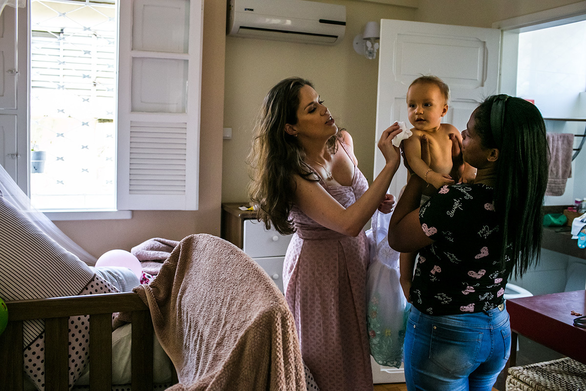 mãe e empregada preparam a aniversariante de 1 ano para cantar parabéns