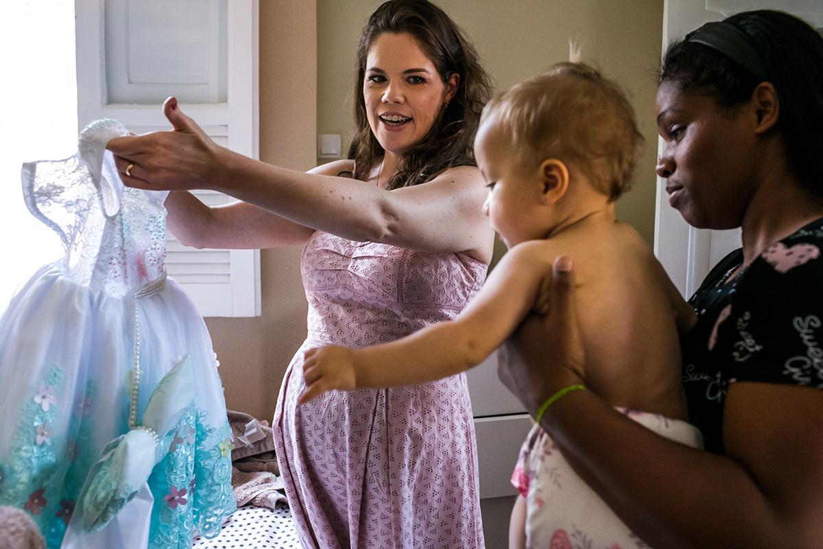 mãe mostra para a filha de 1 ano seu vestido para a hora do parabéns 