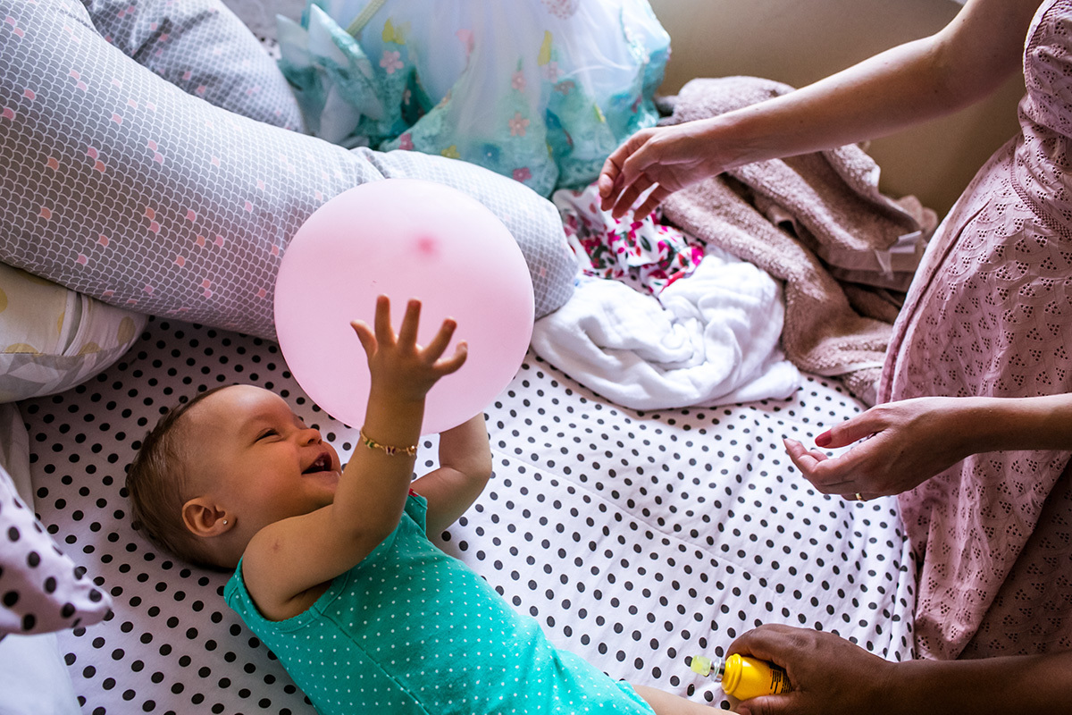 criança brincando com balão até na hora de se trocar no dia do seu aniversário, em foto de Adriana Costa