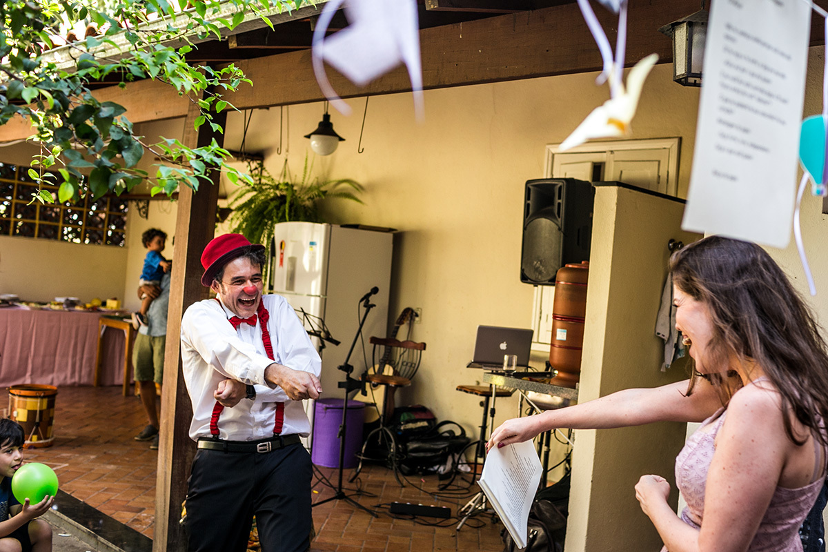 palhaço fingindo que está puxando a mãe da aniversariante por uma corda invisível, em foto de Adriana Costa