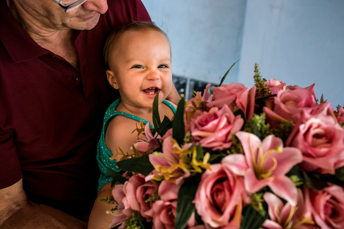 Foto de Adriana Costa da aniversariante vibrando feliz com sua festa de 1 ano
