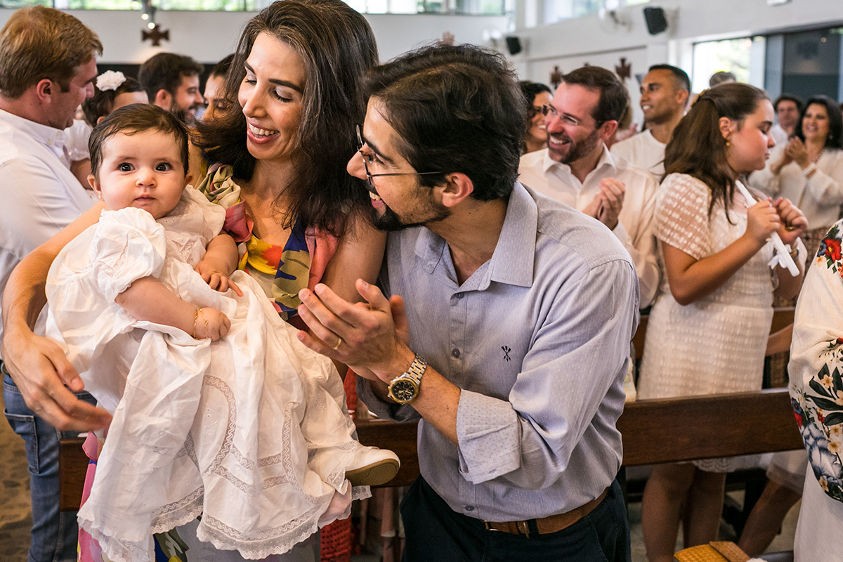 Adriana Costa fotografou pais felizes batendo palma para sua bebê durante a missa de batizado