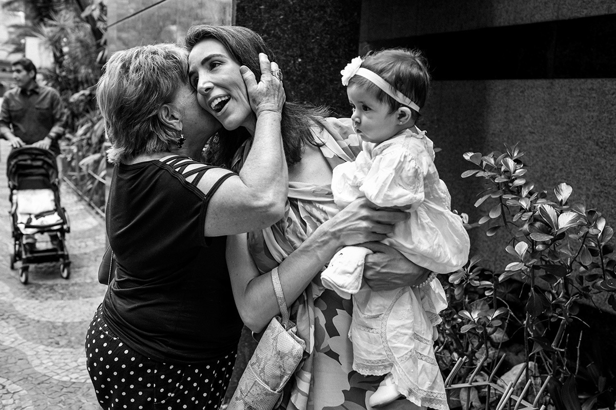 Convidados cumprimentando com carinho a mãe com sua filha pelo batizado