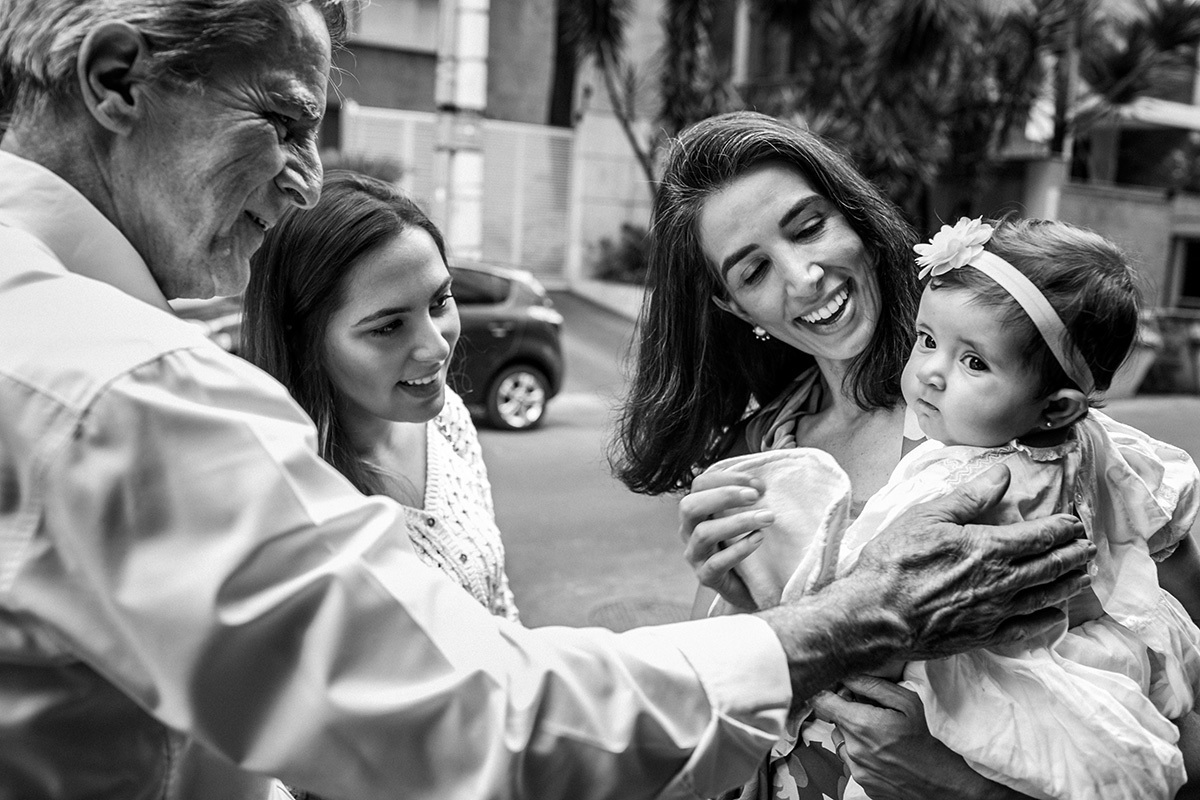 avô cumprimentando sua neta pelo batizado, por Adriana Costa