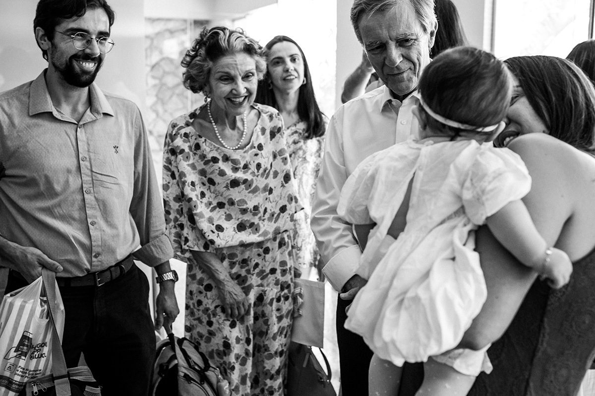 família recebendo bebê na sua festa de batizado