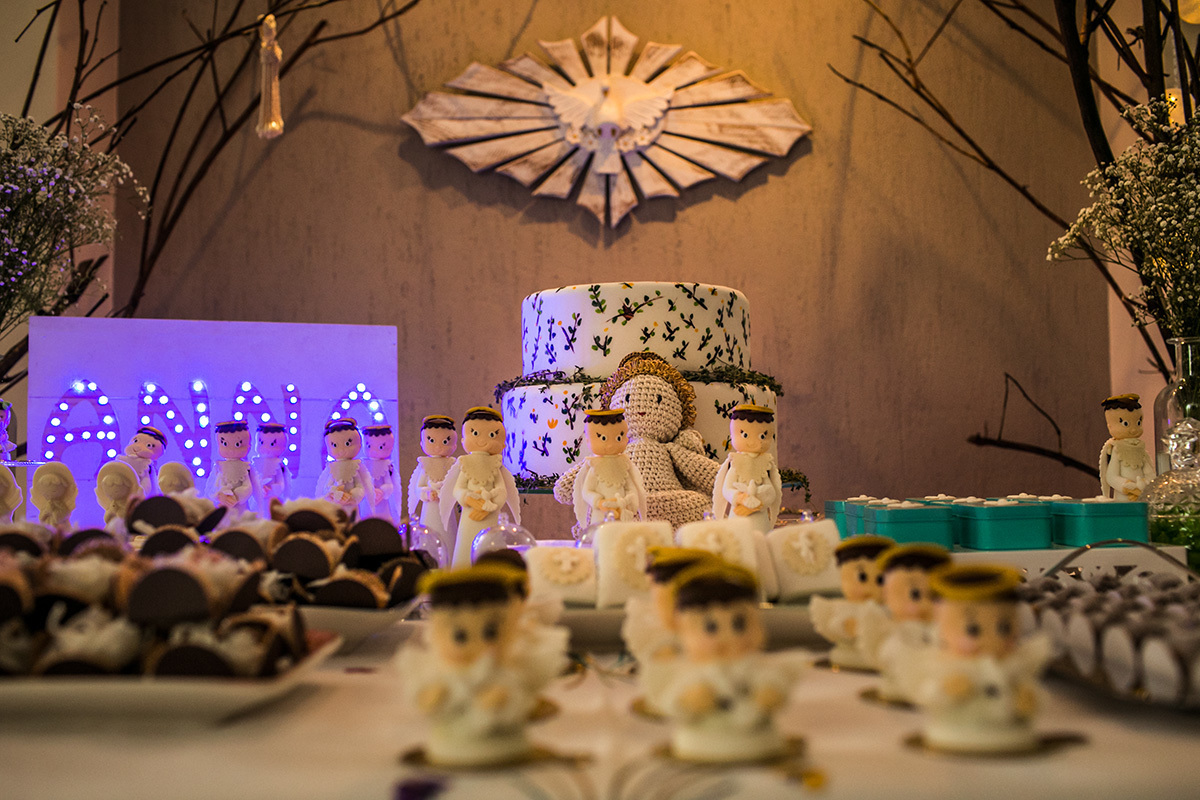mesa de bolo e doces em forma de anjo preparada para a festa de batizado