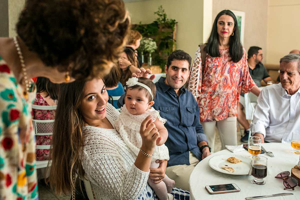 família fazendo festa para a bebê em seu almoço de batismo, por adrianacostafotos