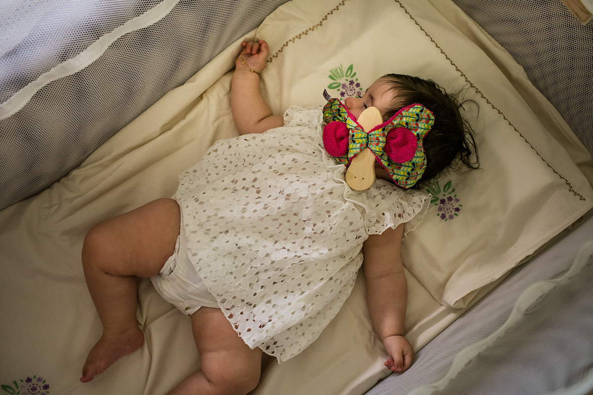 bebê dormindo após terminar sua festa de batizado