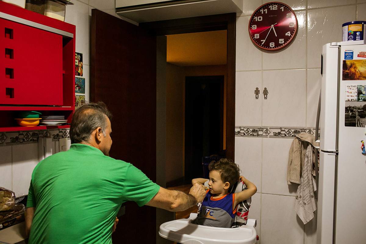 pai e filho na hora do jantar na cozinha da casa