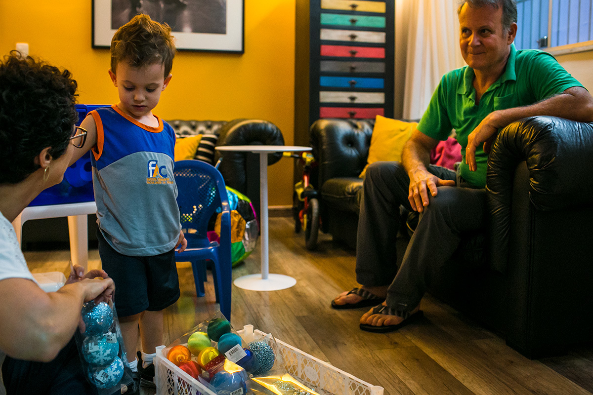 mãe começa junto ao pia mostrar as bolinhas de Natal para o filho
