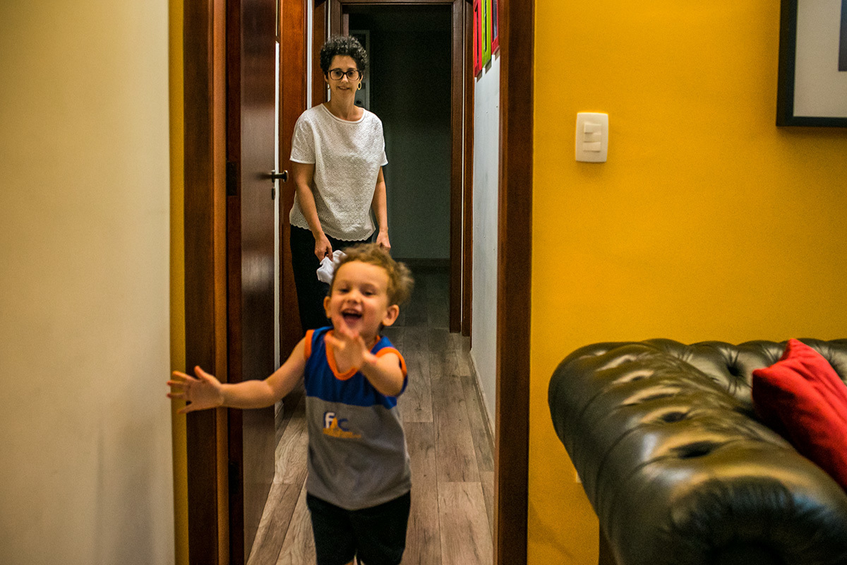 menino corre feliz pelo corredor da casa animado com a montagem da sua árvore de Natal