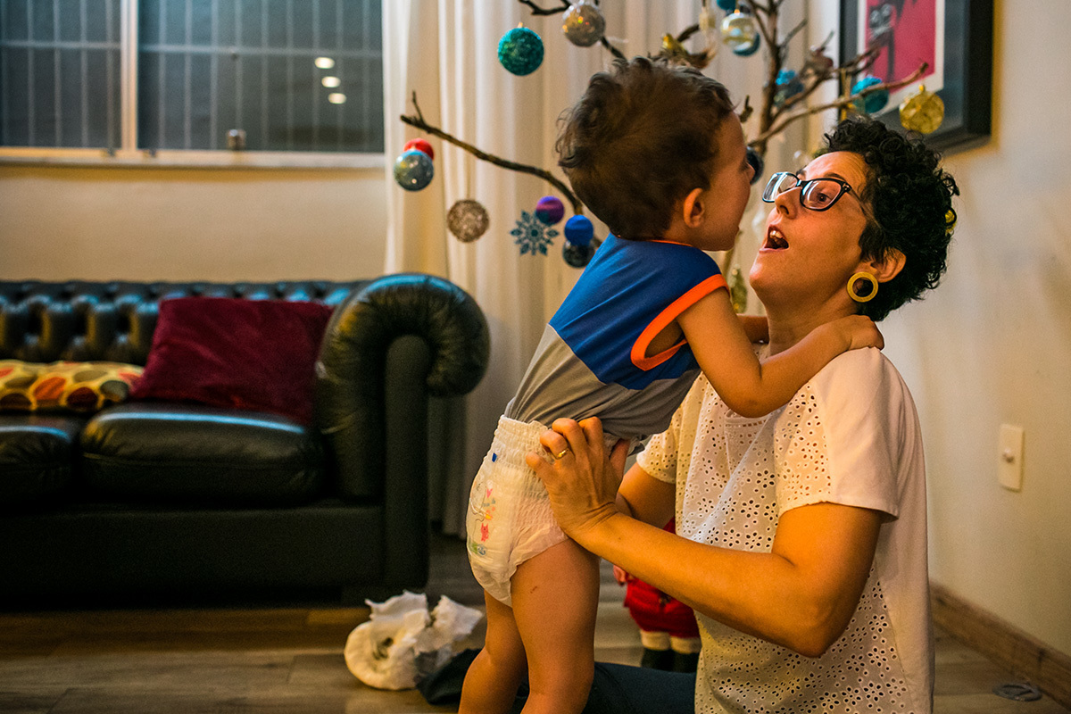 mãe brinca com seu filho no dia de enfeitar a árvore de Natal