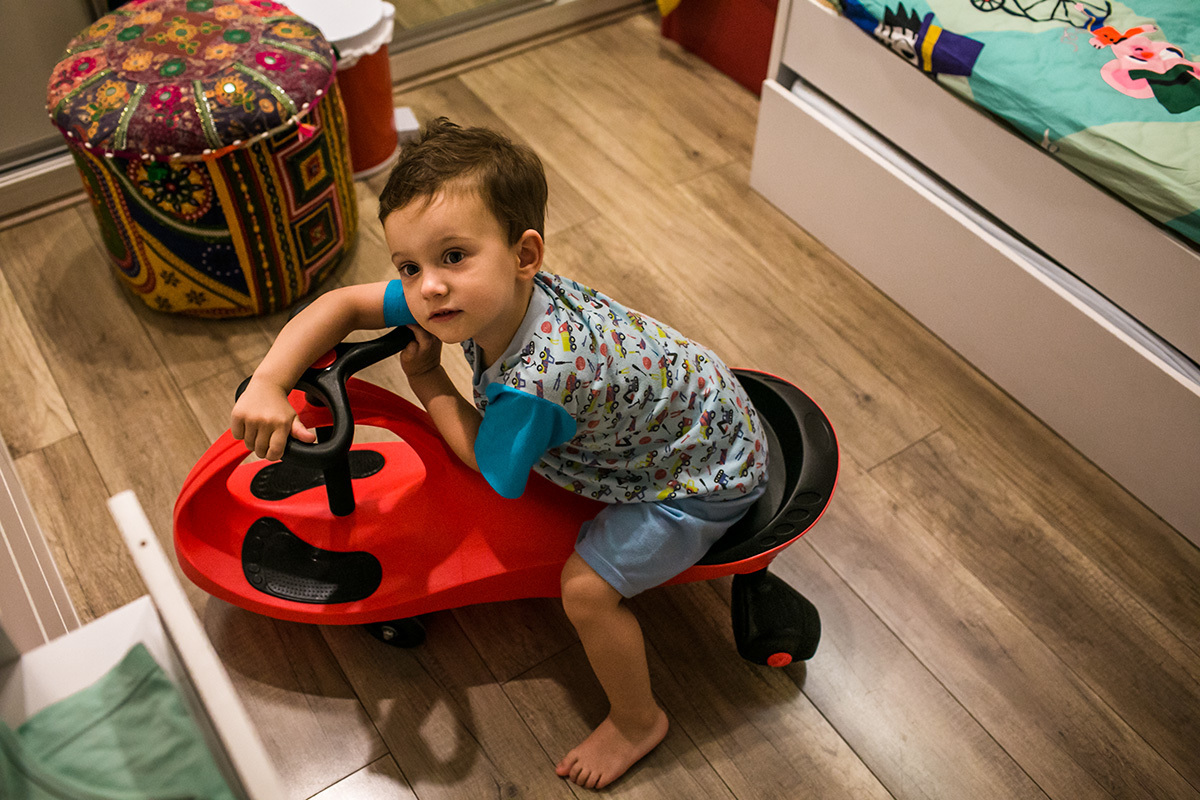 menino anda de carrinho dentro de casa