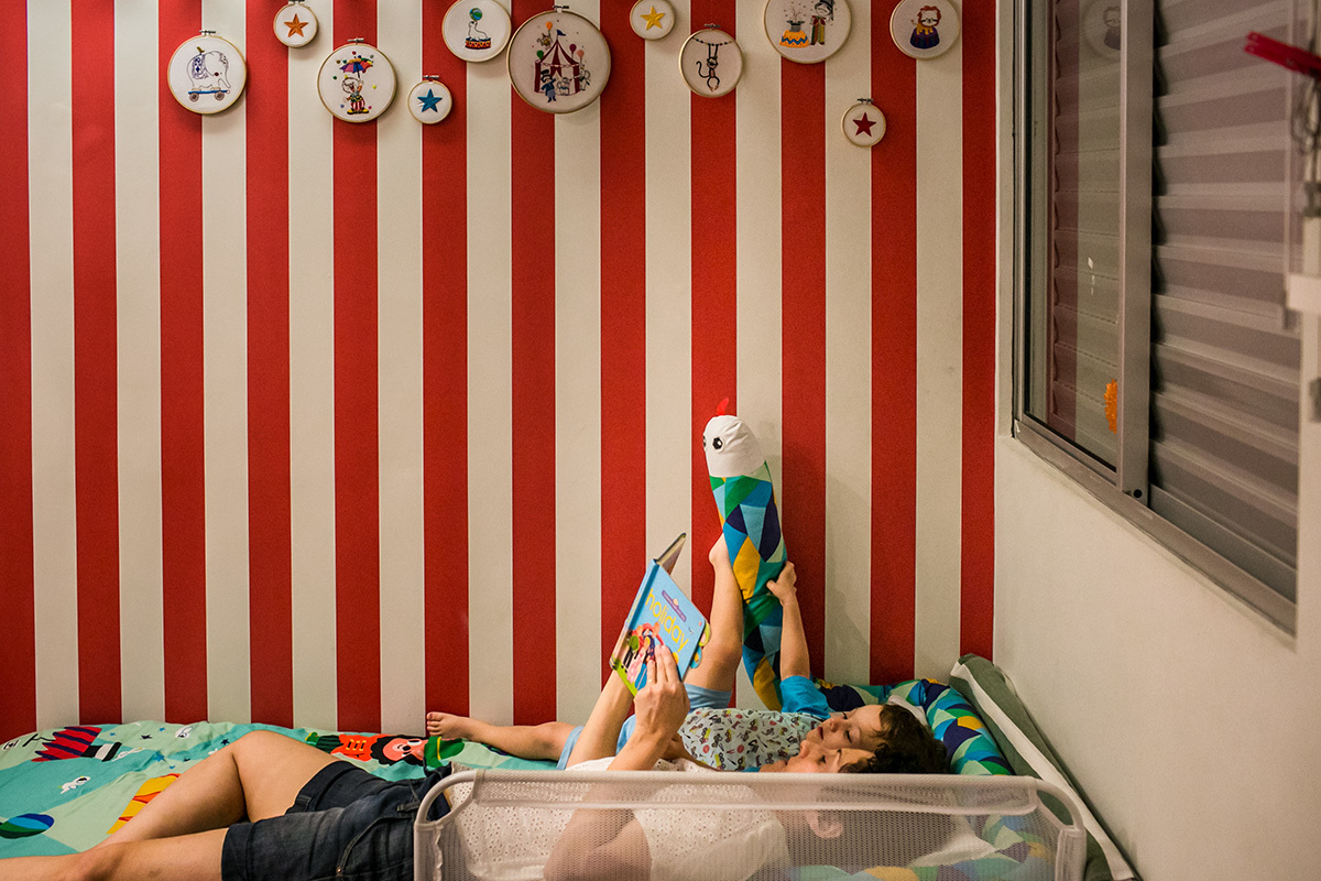 mãe e filho no quarto lendo antes de dormir