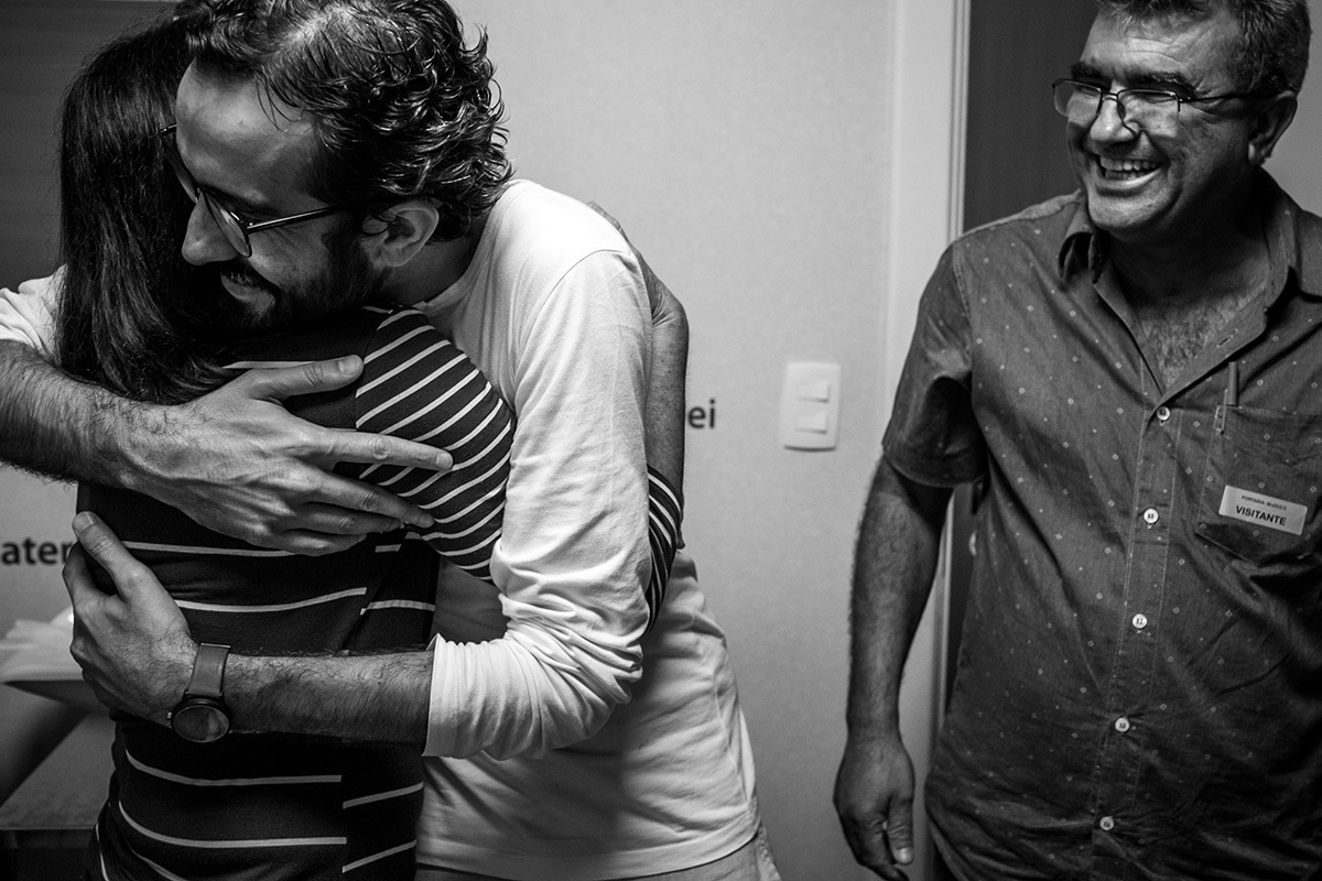 homem que acabou de se tornar pai é abraçado por seus pais