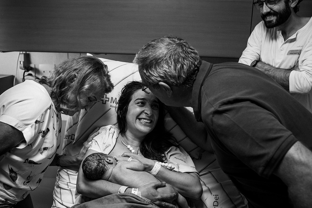 Parturiente recebe o carinho de seus pais após ter o bebê