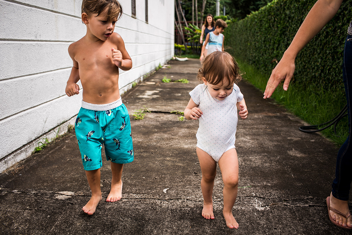 menina e primos brincando de correr no quintal de casa 