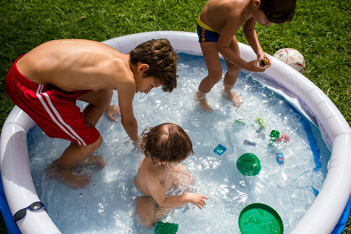 primos brincando na piscina inflável