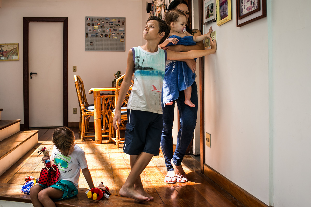 crianças brincam com bonecas e de acender e apagar a luz da sala