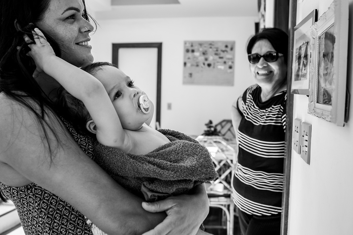menina de 1 ano observa os retratos da parede da casa do avô