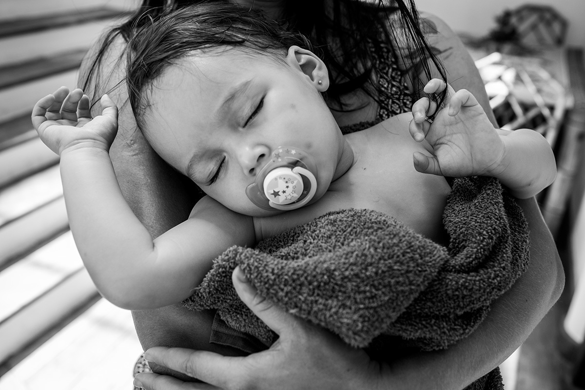 criança dorme no colo de cansaço