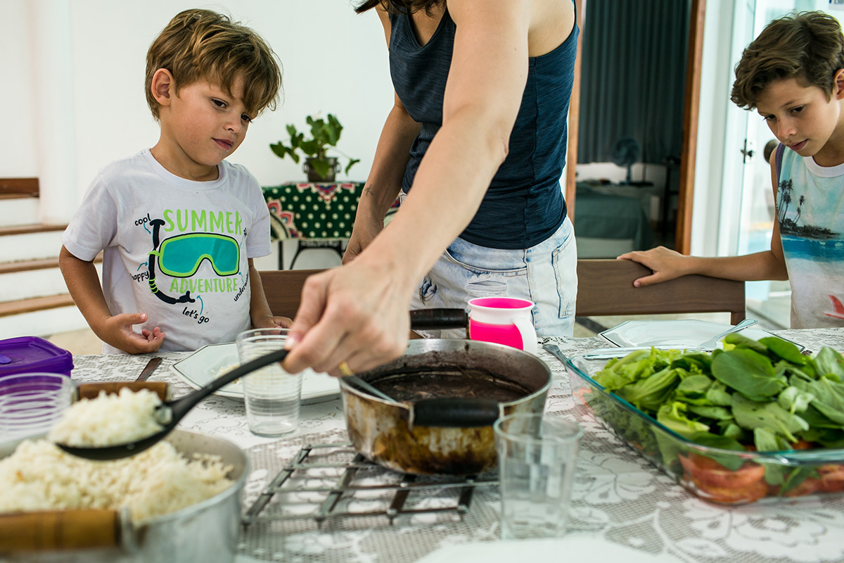 tia serve o almoço dos sobrinhos em um dia de férias