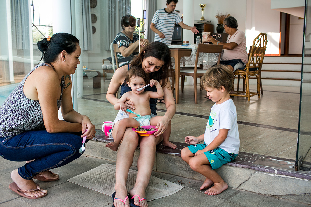 menina de 1 ano almoça após acordar cercada pela família em um dia de férias