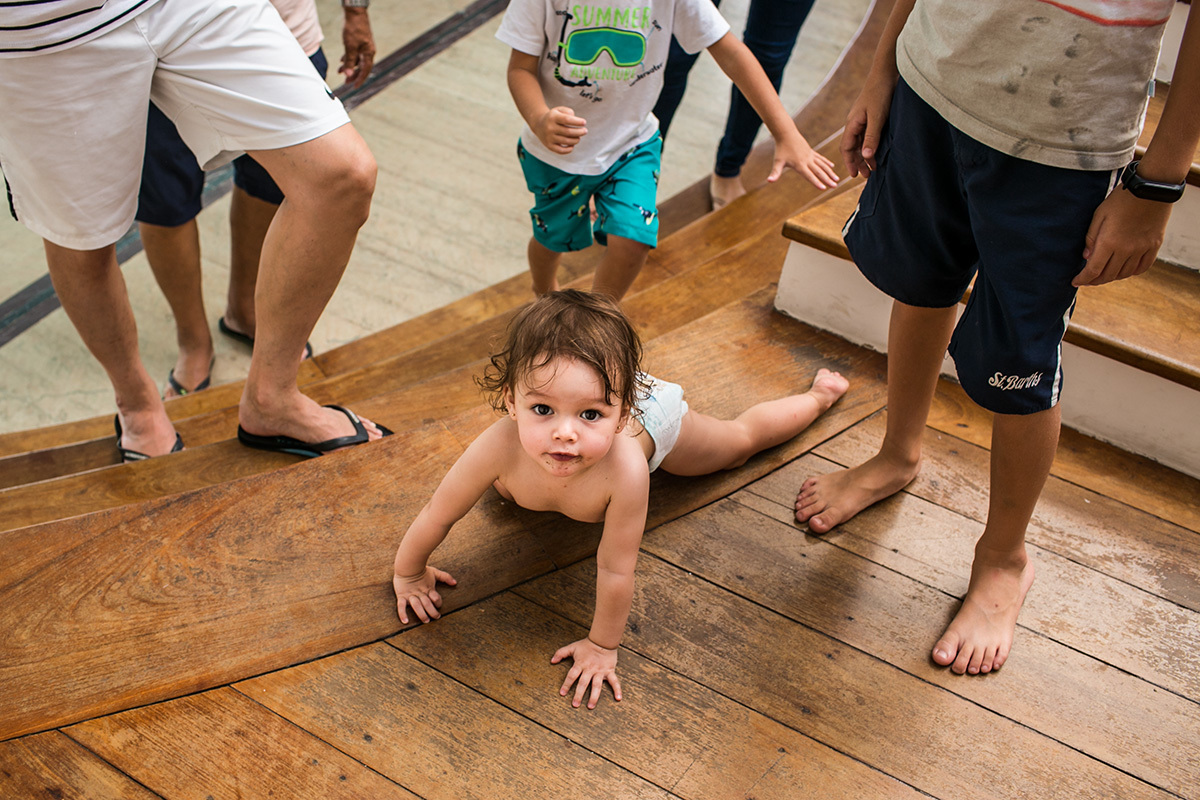 família acompanha menina de 1 ano subir a escada engatinhando