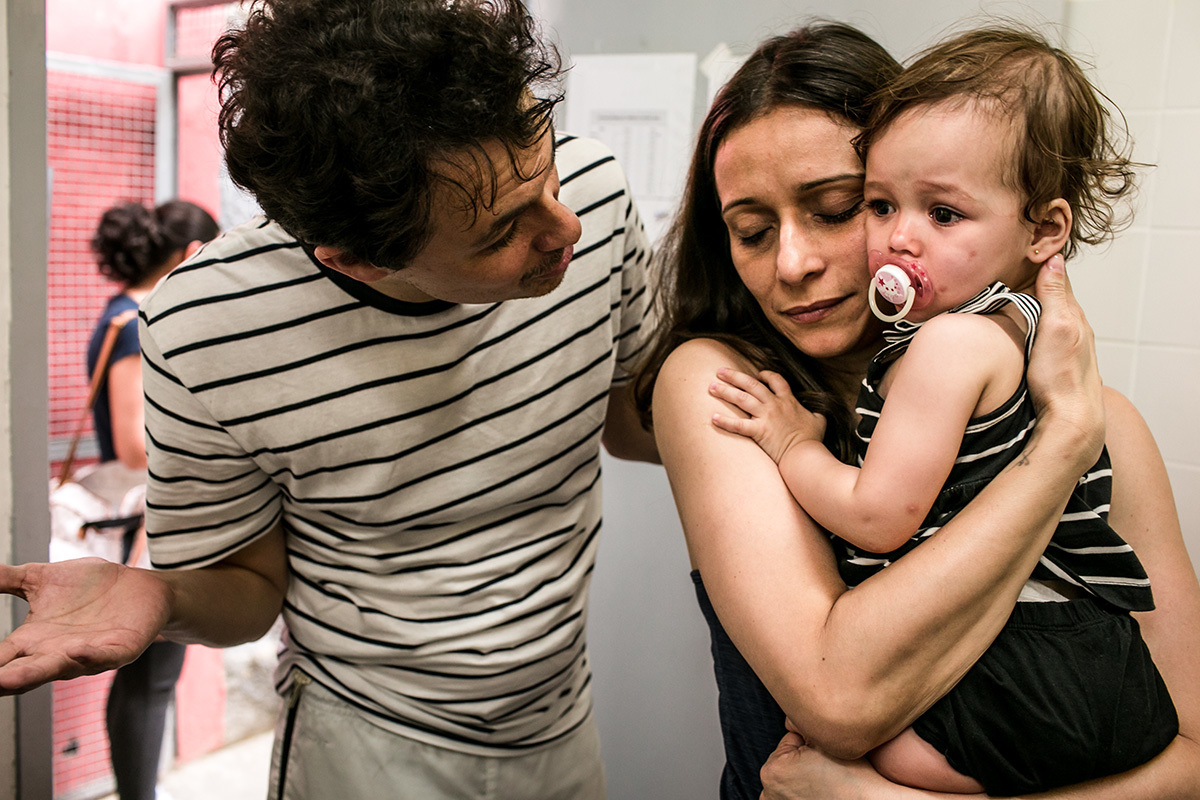 pais consolam sua filha após ser vacinada, por Adriana Costa