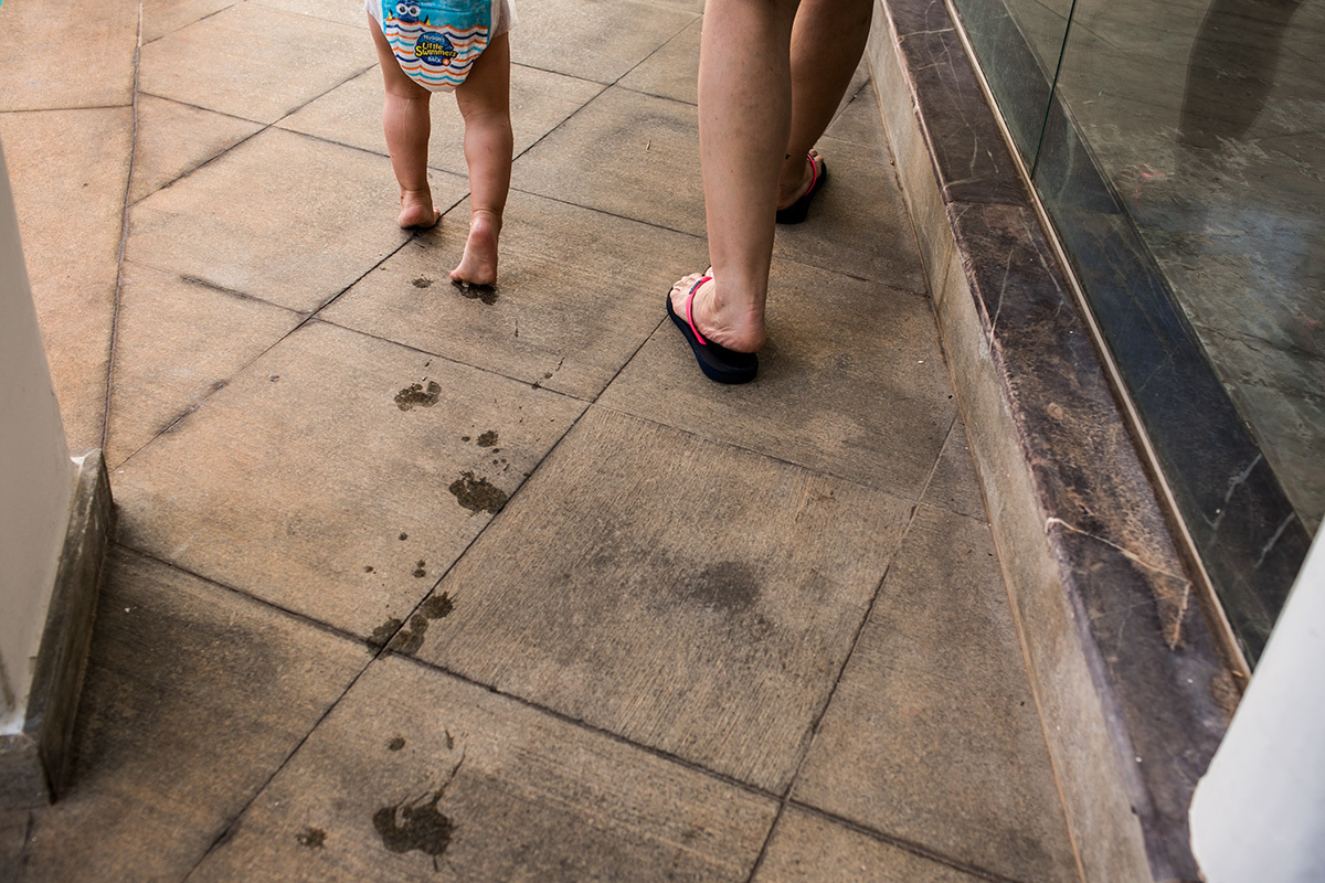 mãe passei com a filha que deixa a marca de seus pés molhados no chão