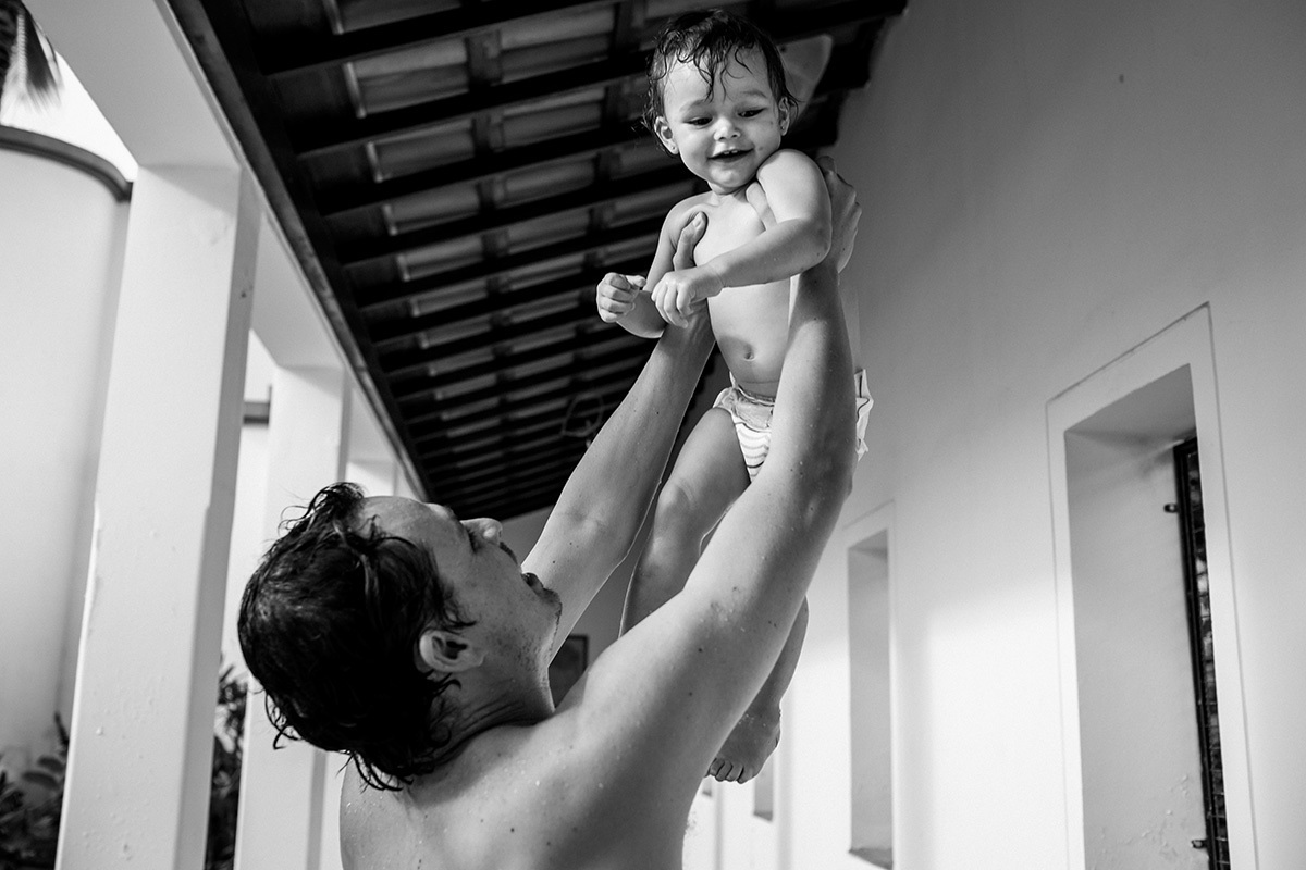 pai brinca com sua filha de jogá-la para o alto