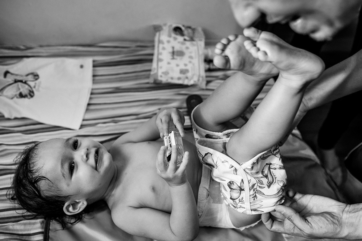 pai troca a roupa da filha após o banho