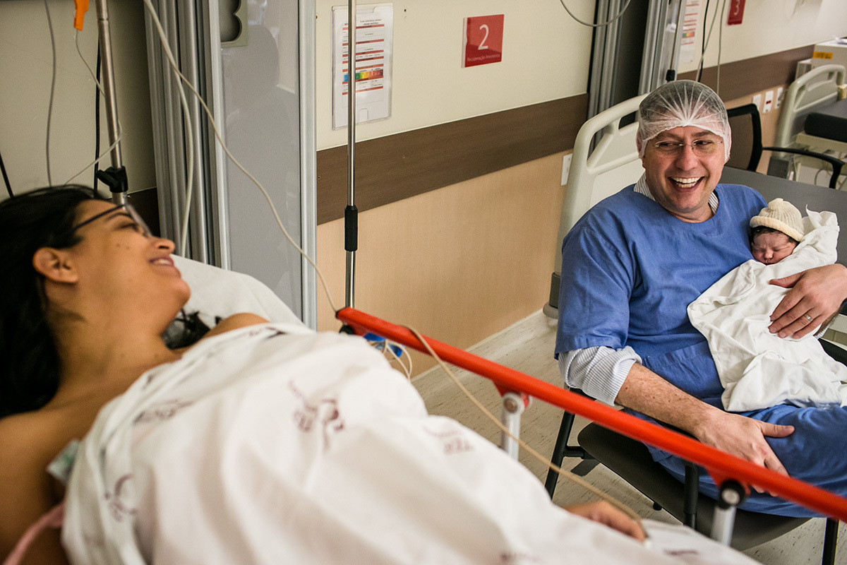 pais alegres na sala de recuperação do pós parto com sua filha aguardando a alta para serem encaminhados para o quarto