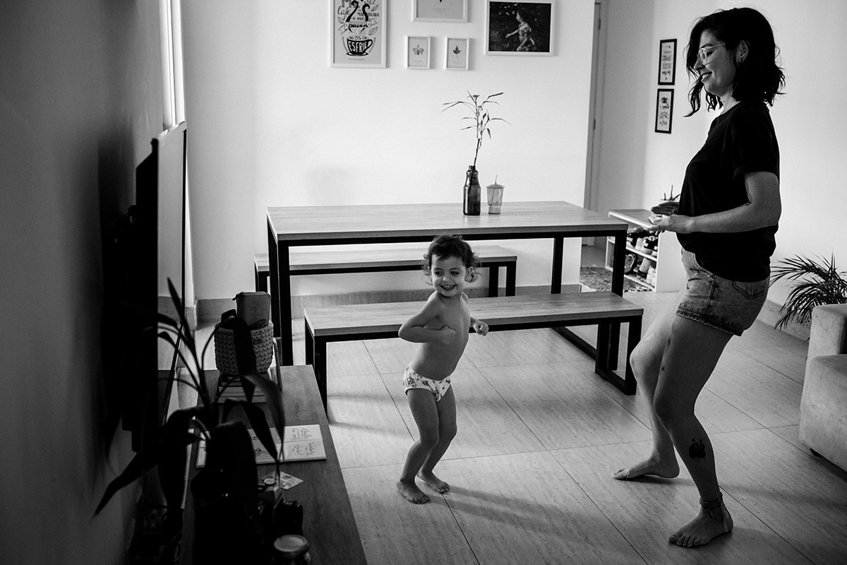mãe se diverte dançando com sua filha de 3 anos