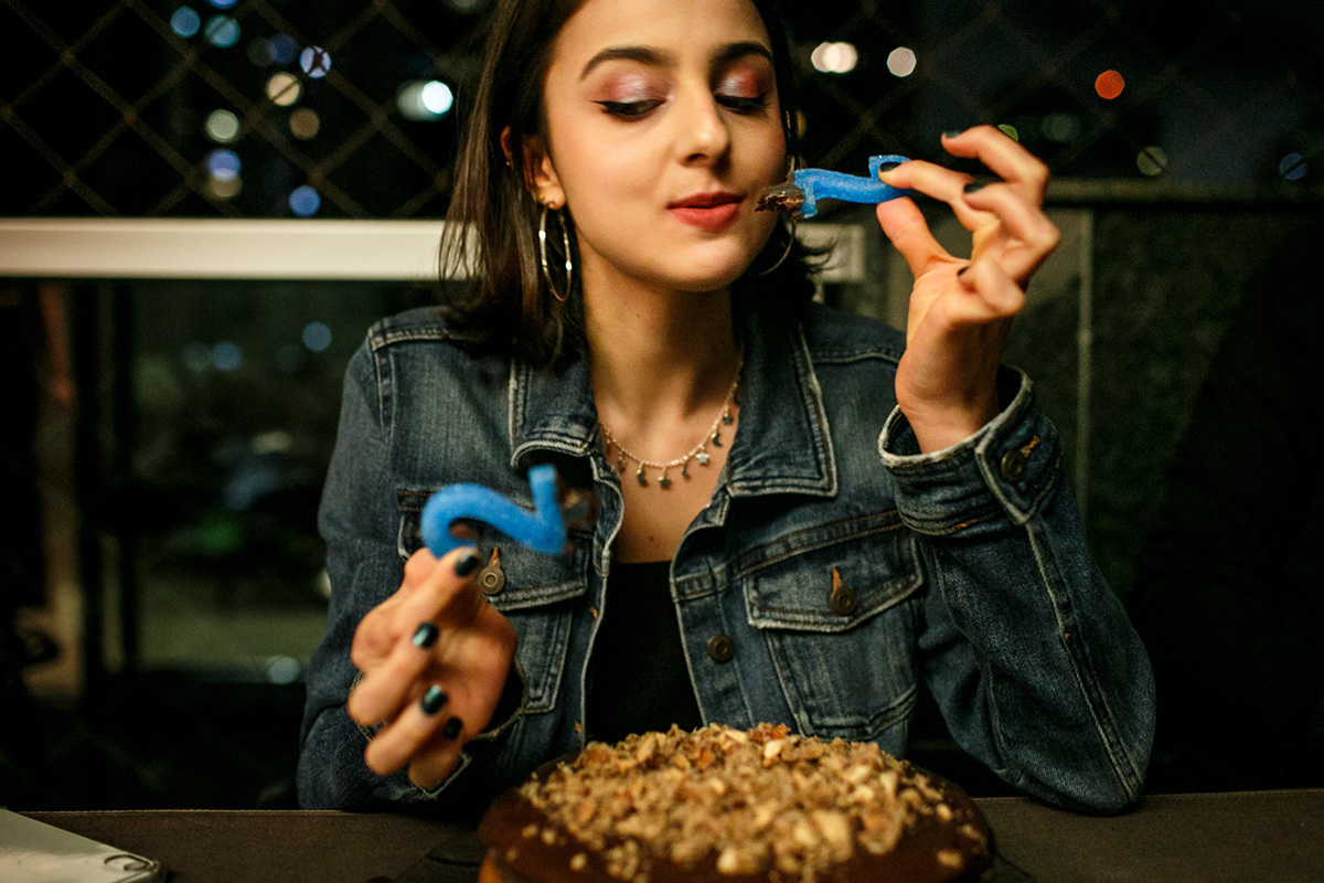 aniversariante lambendo a vela do bolo de seu aniversário que aconteceu durante a pandemia