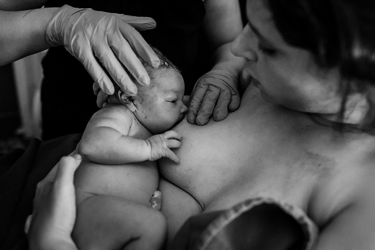bebê em sua primeira amamentação com o apoio da doula que assistiu ao seu nascimento