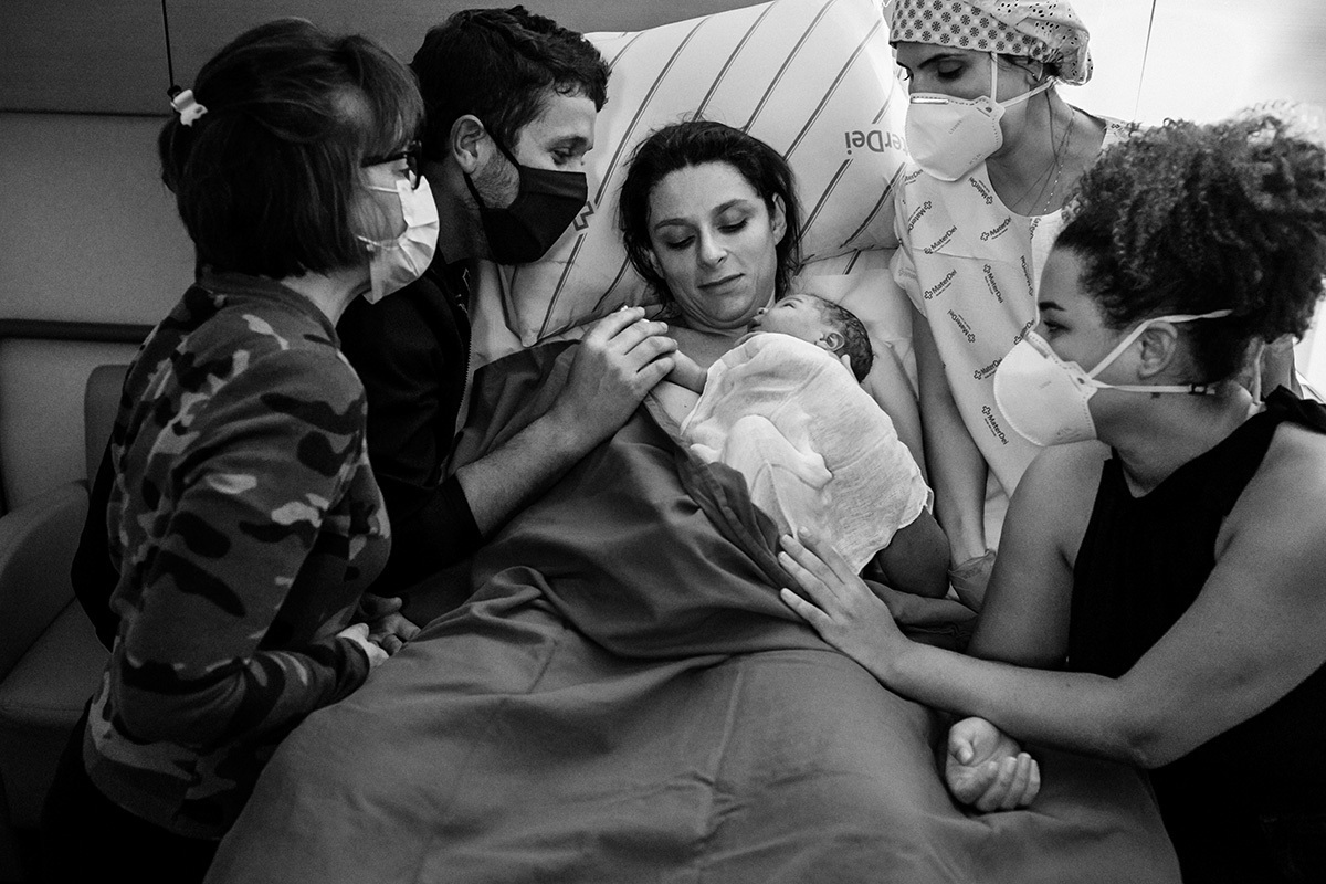 Casal na maternidade Mater Dei com seu bebê que acabou de nascer e a equipe do Instituto Nascer que os assistiu no parto 