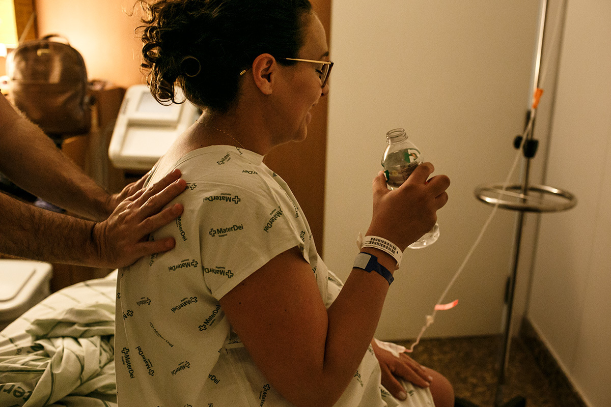 marido massageia a esposa enquanto ela bebe água no dia do parto 