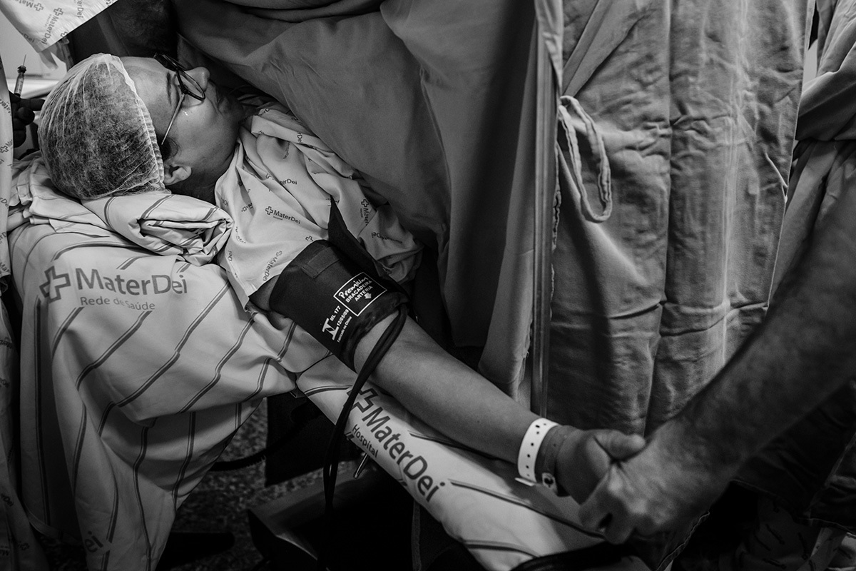 marido da a mão a esposa que chora logo após o nascimento do seu bebê