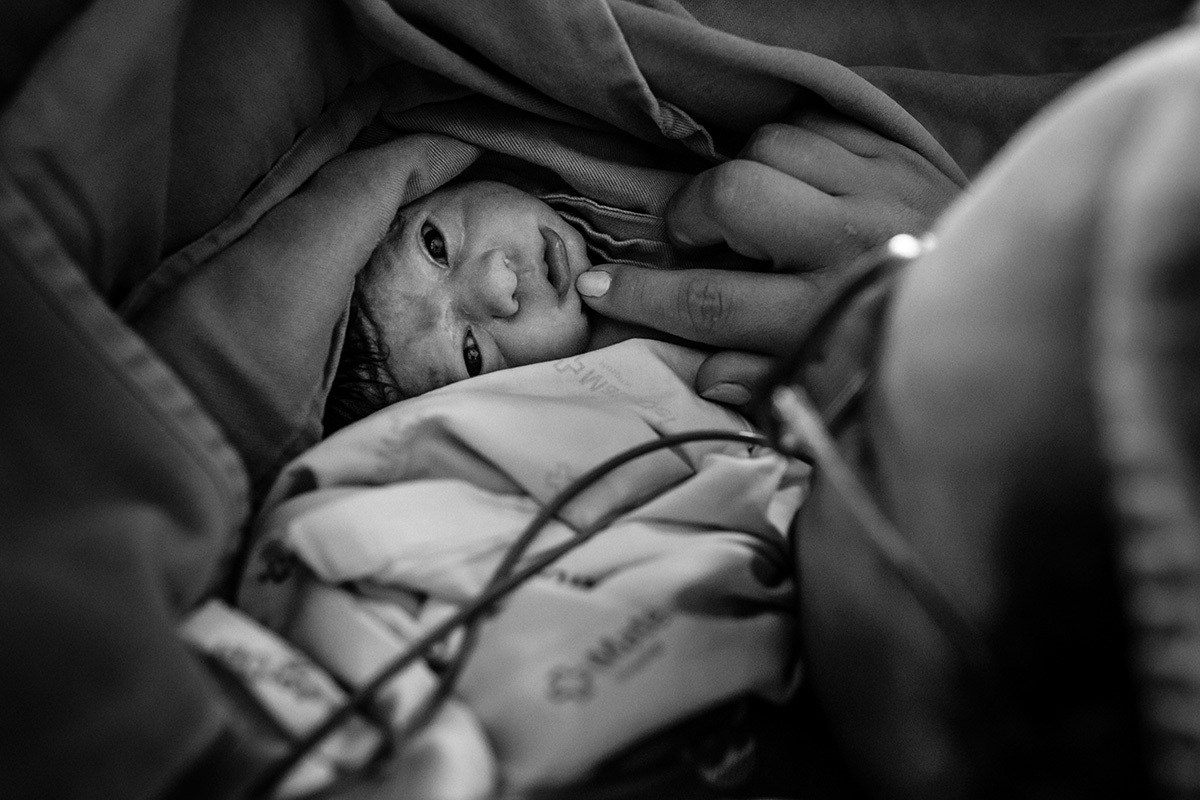 Foto de Adriana Costa da mãe observa seu bebê após a cesárea