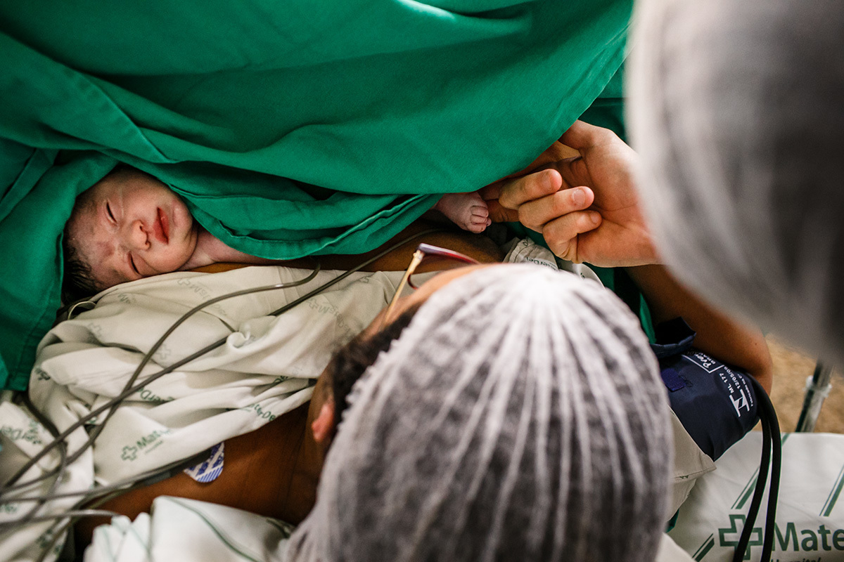 Pai examina o pezinho do bebê que acabou de nascer